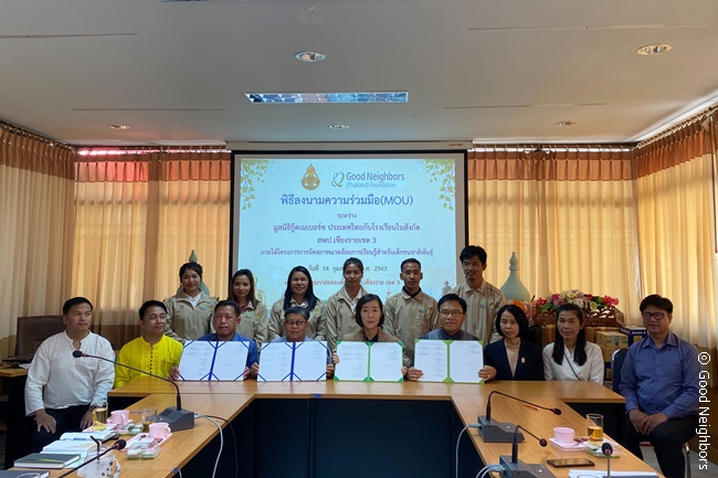 굿네이버스 태국과 치앙라이 교육지원청 업무 협약식 문서를 펴고 있는 모습
