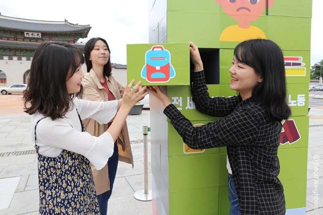 초대형 연필 모형의 젠가를 아동의 희망이 담긴 메시지로 바꾸는 시민의 모습