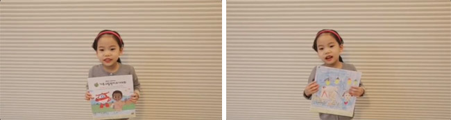 가족그림편지쓰기대회 종이를 들고 있는 여자아이2의 모습,본인이 그린 그림을 들고 있는 여자아이2의 모습