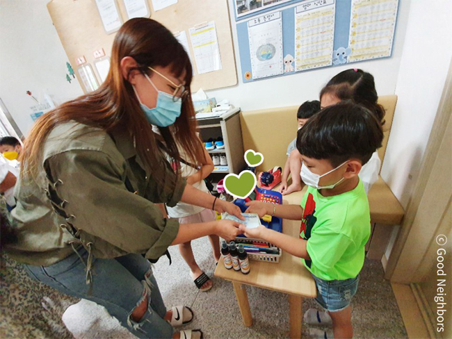 레인보우 마켓 상품을 팔고 거스름돈을 건네는 아이 모습