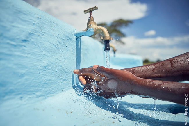 굿워터 프로젝트로 깨끗한 물을 얻게 된 아프리카에서 아이가 깨끗한 물로 손을 씻고 있는 모습