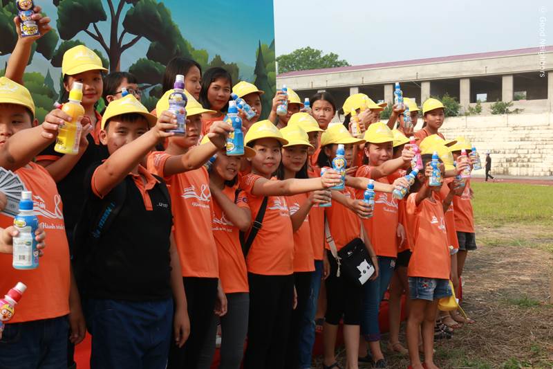 베트남 아동과 지역주민들이 음료수를 들고 있는 모습 