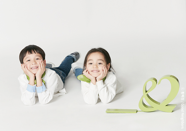 웃고 있는 두 명의 아동과 굿네이버스 CI 이미지
