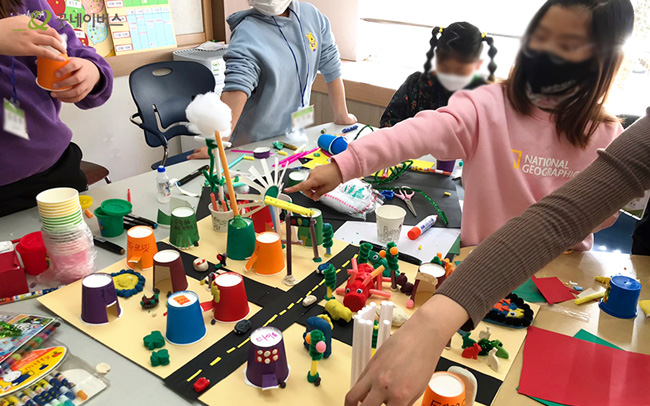 여러 가지 재료를 가지고 마을을 만들어 보는 아이들의 모습