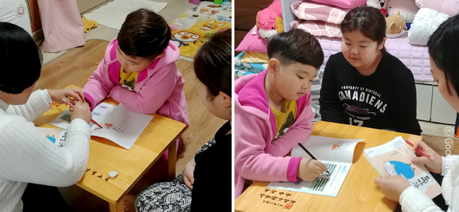 왼쪽은 선생님과 함께 학습지 공부를 하고 있는 산이와 옆에서 지켜보고 있는 한별이 이미지, 오른쪽은 선생님과 함께 학습지 공부를 하는 산이를 옆에서 도와주고 있는 한별이 이미지