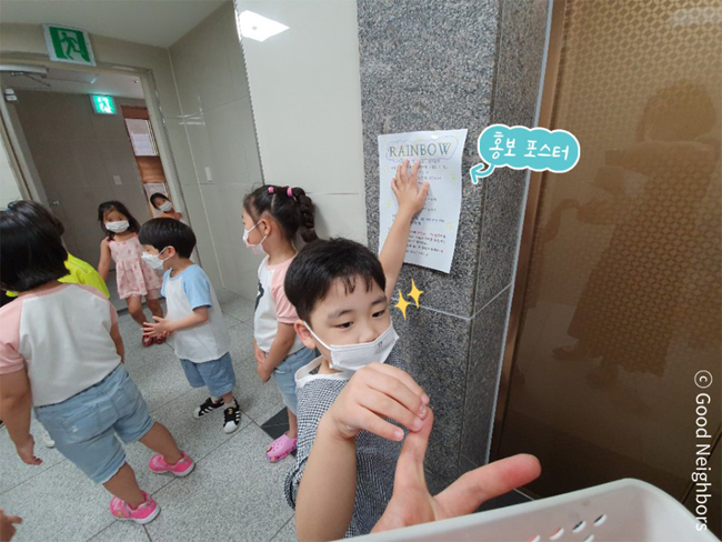 홍보 포스터를 부착하는 어린이의 모습