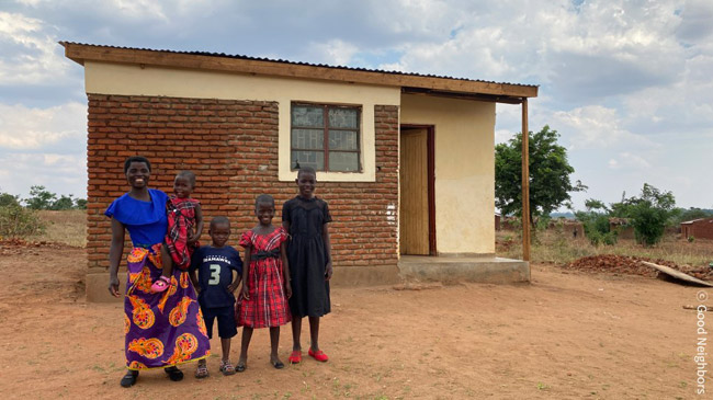 바네사의 가족이 집 앞에서 모여서 웃고 있는 모습