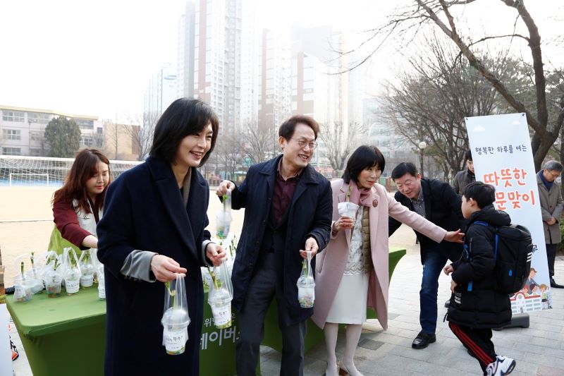 양진옥 굿네이버스 회장과 조희연 서울시교육청 교육감이 등교하는 아이들을 마중하며 권리 화분을 전달하는 모습